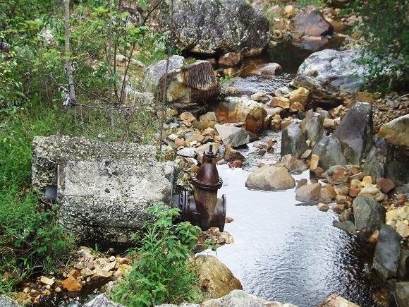 Restos do que sobrou de uma antiga barragem ainda se encontra em uma grande extensão do leito do Rio do Ouro