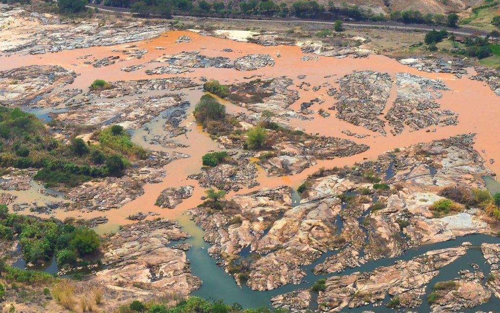 Ruptura da barragem provocou a liberação de volume de 55 milhões a 60 milhões de metro cúbicos de rejeitos de minério no Rio Doce. A lama percorreu mais de 600 quilômetros até chegar ao oceano, matando peixes, a flora, a fauna e disparando uma crise social e ambiental que afetou a subsistência e o acesso à água da população, incluindo indígenas Krenak e milhares de pescadores. Foto: Fred Loureiro / SECOM ES